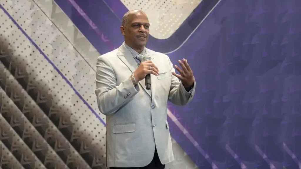 Tyrone Waller speaking on stage with a microphone
